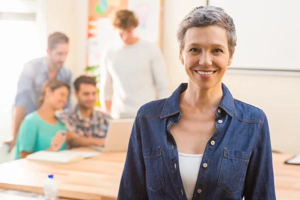 Creative businesswoman smiling at the camera — Stock Photo, Image