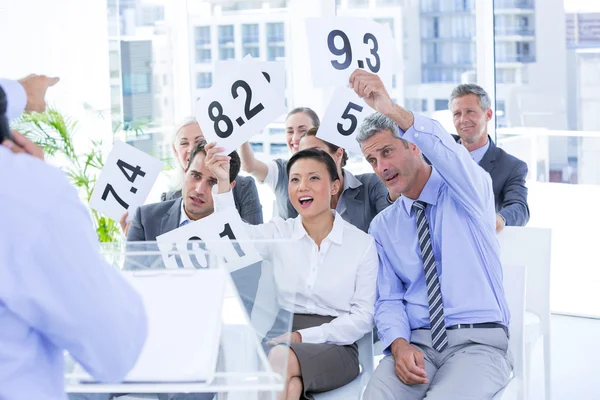 Equipo de negocios sonriente mostrando papel con calificación — Foto de Stock