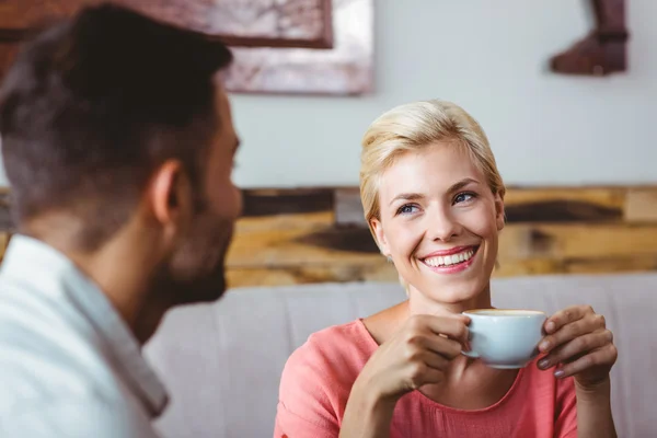 Casal com xícara de café sentado no sofá — Fotografia de Stock