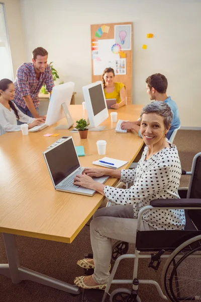 Creative casual businesswoman in wheelchair — Stock Photo, Image