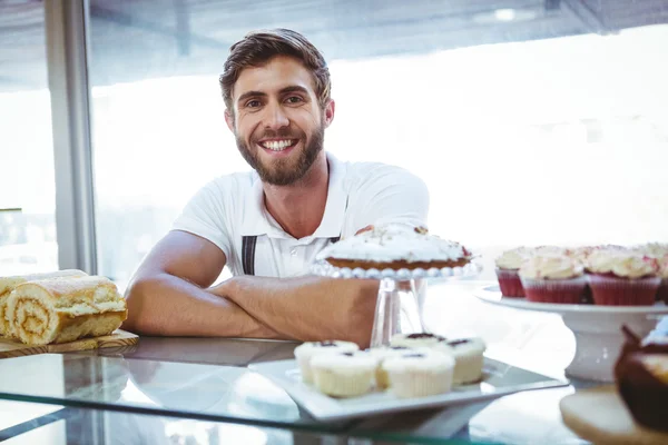 Smiling worker posing behind the counter arm crossed — Stock Photo, Image