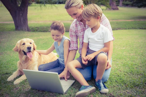 Famiglia con il loro cane utilizzando il computer portatile — Foto Stock