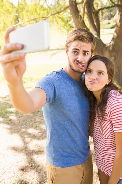 Cute para robi selfie w parku — Zdjęcie stockowe