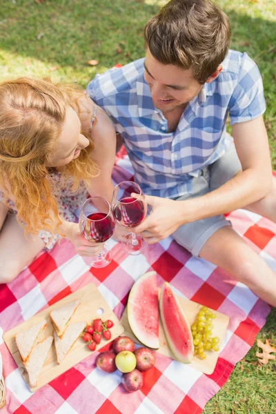 Jovem casal em um piquenique beber vinho — Fotografia de Stock