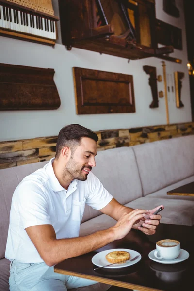 Joven tomando una taza de café y pastelería —  Fotos de Stock