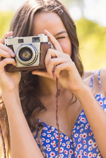 Půvabná brunetka v parku pomocí retro fotoaparát — Stock fotografie