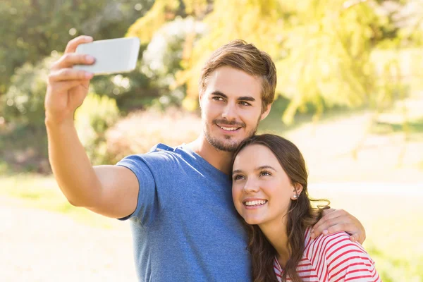 Bonito casal fazendo selfie no parque — Fotografia de Stock