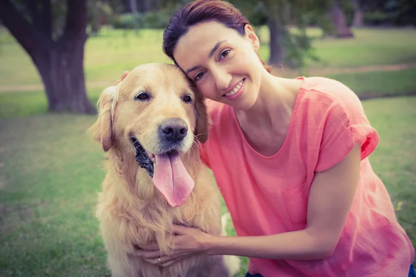 Hübsche Brünette schaut mit ihrem Hund in die Kamera — Stockfoto