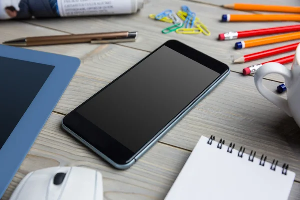 Smartphone naast de kop Kladblok tablet — Stockfoto