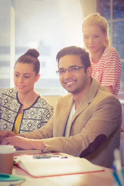 Colleagues using laptop at office — Stock Photo, Image