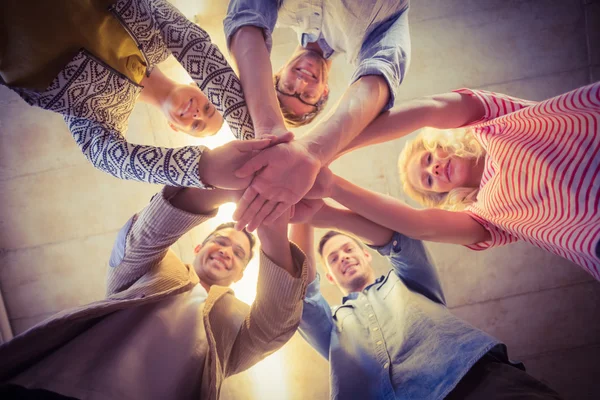 Happy business team joining their hands — Stock Photo, Image