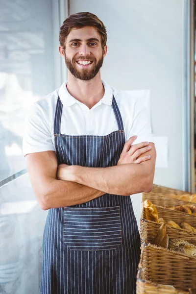 Smiling server in apron arm cross — стоковое фото