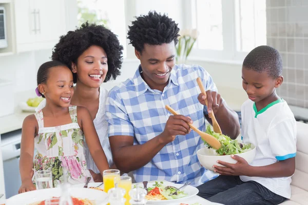 Glückliche Familie setzt sich zum gemeinsamen Abendessen zusammen — Stockfoto