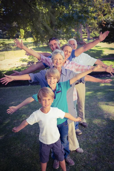 Lycklig familj med armarna utsträckta i parken — Stockfoto