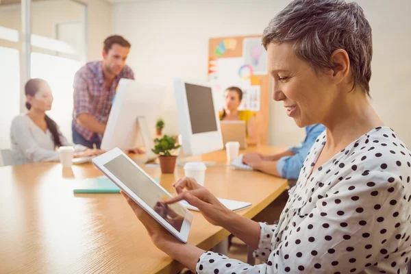 Lachende creatieve zakenvrouw met behulp van een Tablet PC — Stockfoto