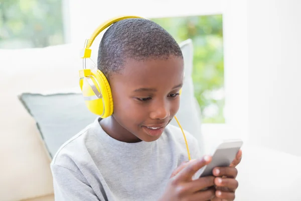 Little boy listening to music on the couch — Stock Photo, Image