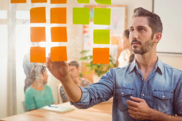 Hombre de negocios mirando su puesto en la pared — Foto de Stock