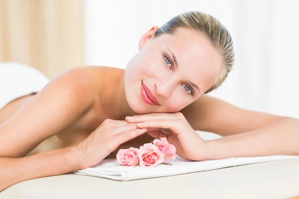 Peaceful blonde lying on towel smiling at camera — Stock Photo, Image