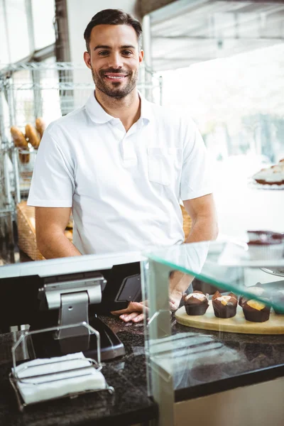 Trabajador sonriente posando detrás del mostrador — Foto de Stock