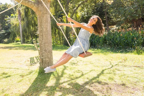 Pretty brunette swinging in park — Stock Photo, Image