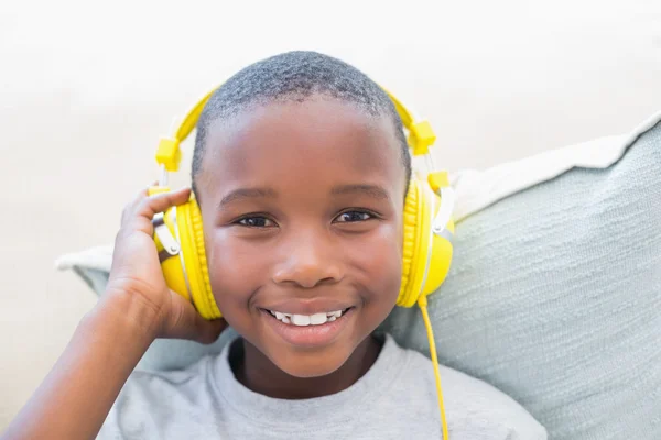 Menino ouvindo música no sofá — Fotografia de Stock