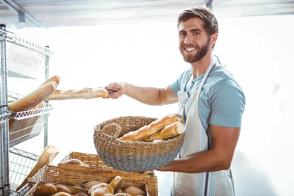 Porträt eines glücklichen Arbeiters mit einem Korb Brot — Stockfoto