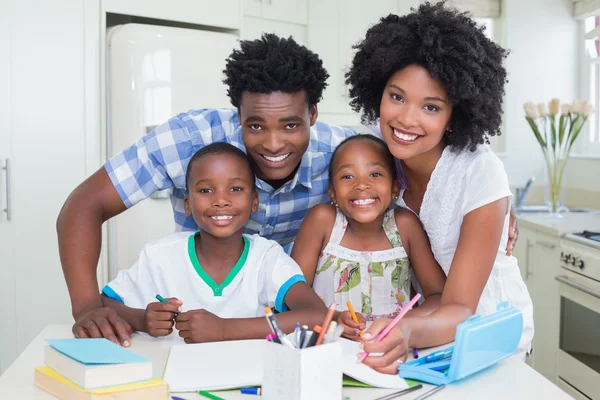 Счастливые родители помогают детям с домашней работой — стоковое фото
