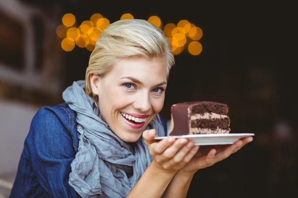 Loira sorridente segurando um bolo de chocolate — Fotografia de Stock