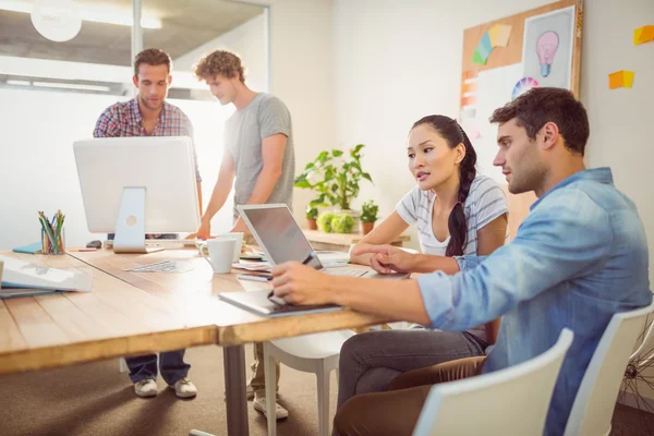 Creative business team gathered around laptops — Stock Photo, Image