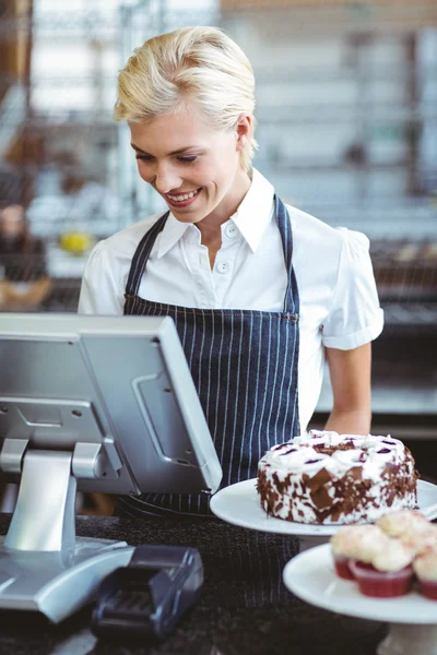 Empleado sonriente usando calculadora en contador — Foto de Stock