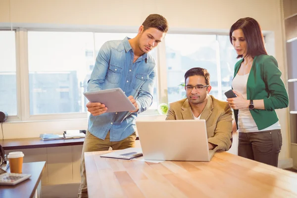 Colleagues using laptop in office — Stock Photo, Image