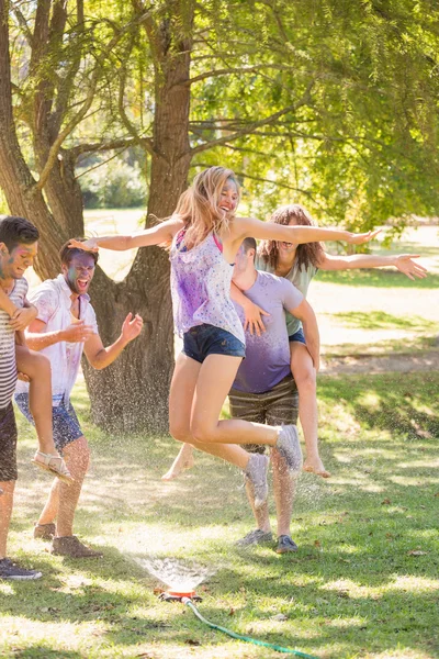 Junge Freunde amüsieren sich mit Schlauch im Park — Stockfoto