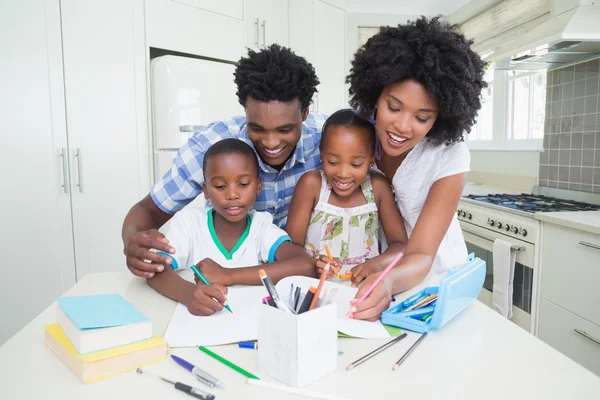 Šťastní rodiče pomoci dětem s úkoly — Stock fotografie