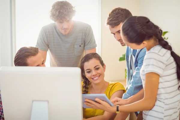 Creative business team gathered around a tablet — Stock Photo, Image
