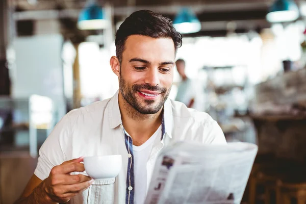 Homem tendo xícara de café lendo jornal — Fotografia de Stock