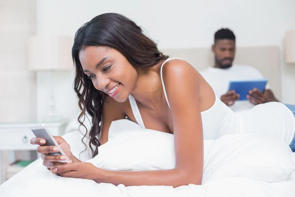 Relaxed couple using technology on bed — Stock Photo, Image