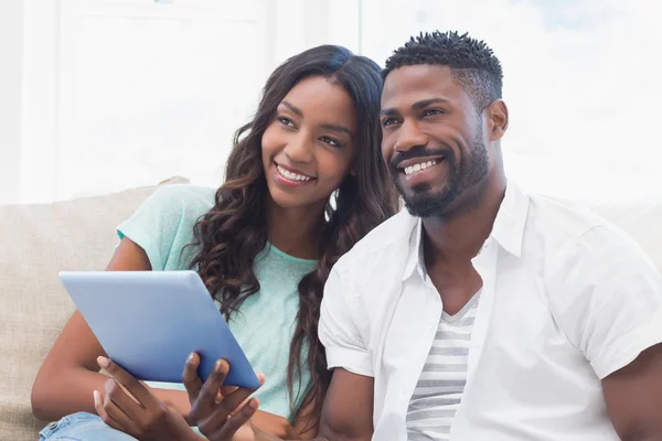 Pareja usando la tableta juntos en el sofá —  Fotos de Stock