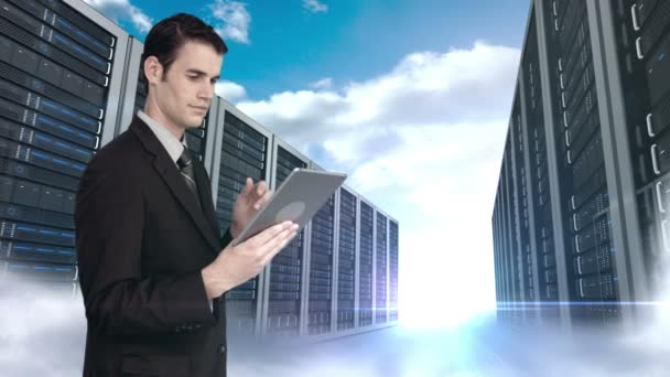 Empresario usando tableta frente a la torre del servidor — Vídeos de Stock