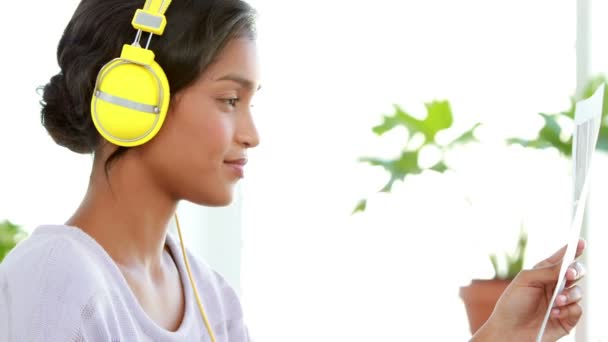 Ділова жінка читає під час прослуховування музики — стокове відео