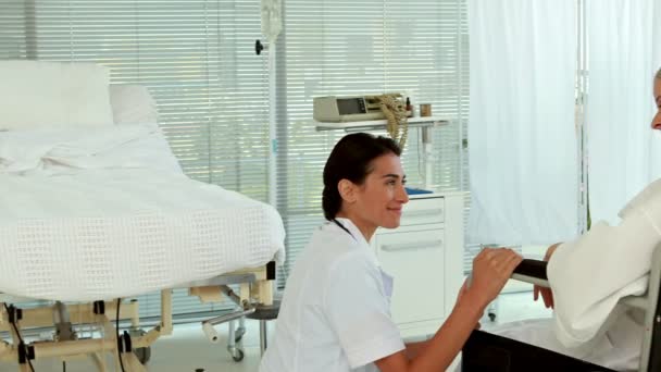 Médico hablando con paciente en silla de ruedas — Vídeos de Stock