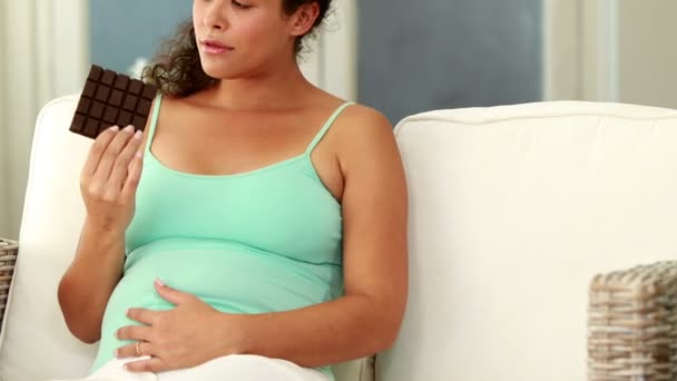 Беременная женщина ест шоколад — стоковое видео