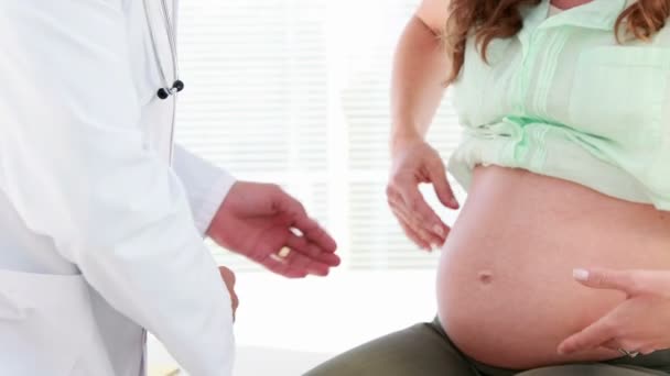 Беременная женщина проходит обследование у врача — стоковое видео