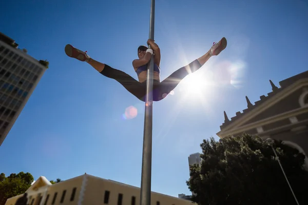 Woman doing gymnastics on street sign — Stock Photo, Image