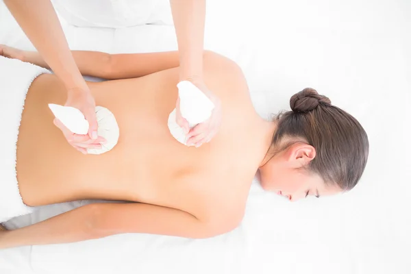 Brunette enjoying herbal compress massage — Stock Photo, Image