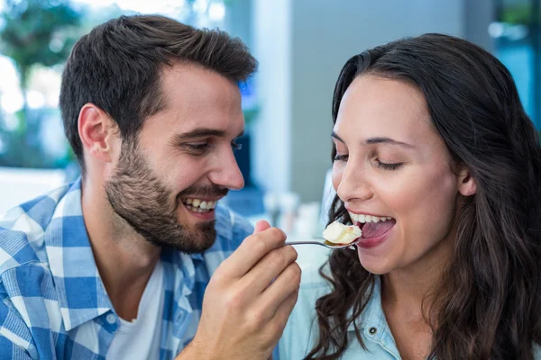 Junges glückliches Paar füttert sich gegenseitig mit Kuchen — Stockfoto