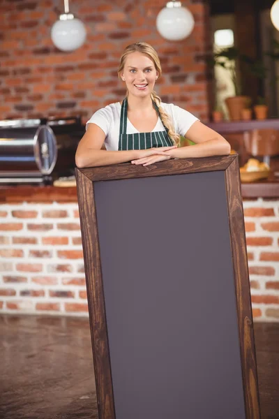 Mooie serveerster houden een grote schoolbord — Stockfoto