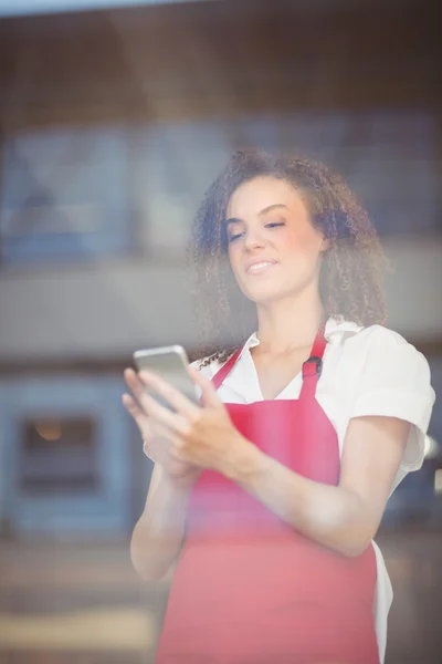 Smiling waitress sending a text — Stock Photo, Image