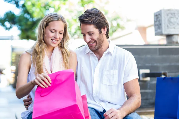 Casal olhando em sacos de compras — Fotografia de Stock