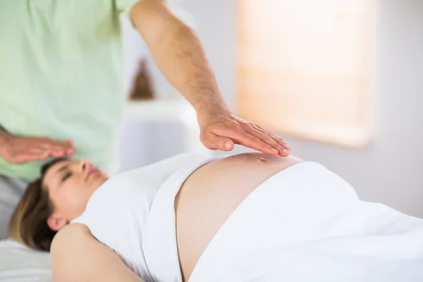 Relajada mujer embarazada recibiendo tratamiento reiki — Foto de Stock