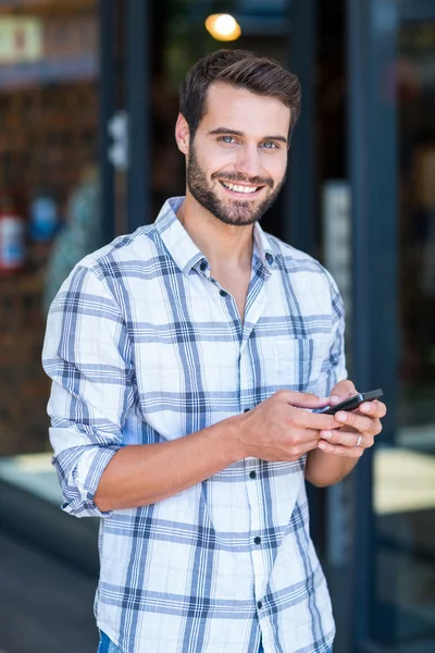 Hipster man using his smartphone in the city — Stock Photo, Image